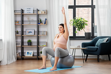 Image showing pregnant woman exercising on fitness ball at home