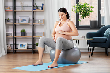 Image showing pregnant woman exercising on fitness ball at home