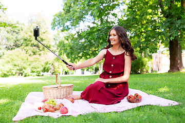 Image showing happy woman with smartphone taking selfie at park