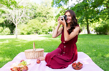 Image showing happy woman with camera on picnic at park