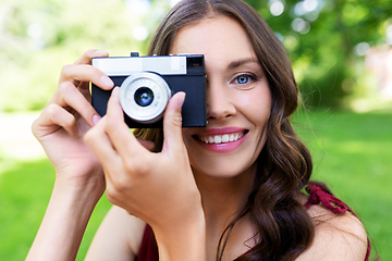 Image showing happy woman with camera photographing at park