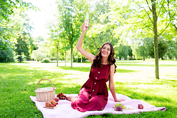 Image showing happy woman with picnic basket and drink at park