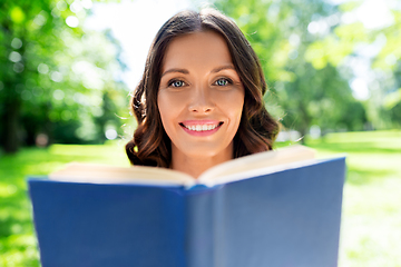 Image showing happy smiling woman reading book at summer park