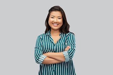 Image showing happy asian woman with crossed arms on grey