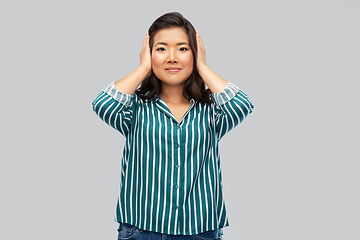 Image showing asian woman closing ears by hands