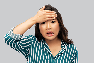 Image showing stressed asian woman holding to her head