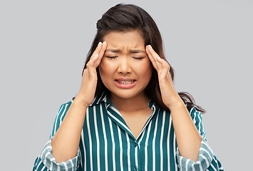 Image showing stressed asian woman holding to her head