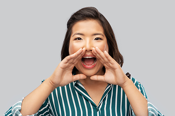 Image showing young asian woman calling for someone