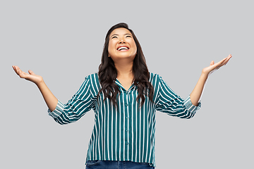 Image showing happy smiling asian young woman looking up