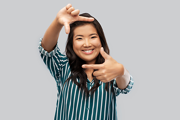 Image showing happy asian woman making frame of fingers