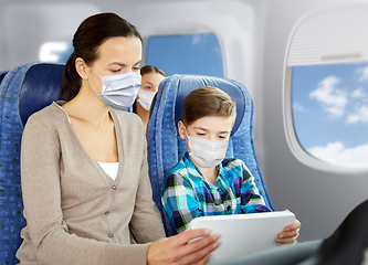 Image showing mother and son in masks traveling by plane