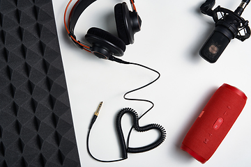 Image showing Microphone, headphones and portable stereo speaker on on white background with copy space and acoustic foam panel