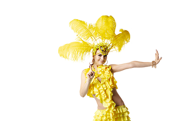 Image showing Beautiful young woman in carnival, stylish masquerade costume with feathers dancing on white studio background.