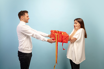 Image showing Beautiful couple in love on blue studio background. Valentine\'s Day, love and emotions concept