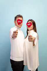 Image showing Beautiful couple in love on blue studio background. Valentine\'s Day, love and emotions concept