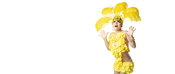 Image showing Beautiful young woman in carnival, stylish masquerade costume with feathers dancing on white studio background.