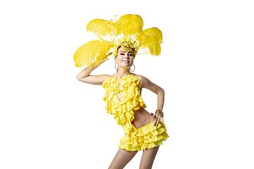 Image showing Beautiful young woman in carnival, stylish masquerade costume with feathers dancing on white studio background.