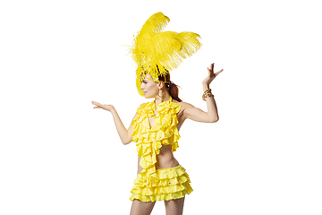 Image showing Beautiful young woman in carnival, stylish masquerade costume with feathers dancing on white studio background.