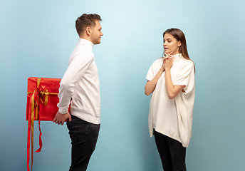 Image showing Beautiful couple in love on blue studio background. Valentine\'s Day, love and emotions concept