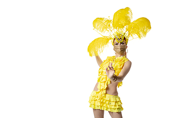 Image showing Beautiful young woman in carnival, stylish masquerade costume with feathers dancing on white studio background.