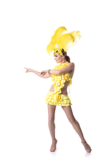 Image showing Beautiful young woman in carnival, stylish masquerade costume with feathers dancing on white studio background.