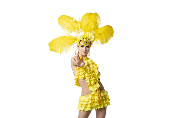 Image showing Beautiful young woman in carnival, stylish masquerade costume with feathers dancing on white studio background.