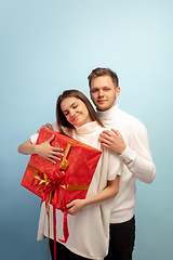 Image showing Beautiful couple in love on blue studio background. Valentine\'s Day, love and emotions concept