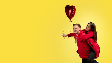 Image showing Beautiful couple in love on yellow studio background. Valentine\'s Day, love and emotions concept