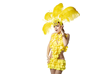 Image showing Beautiful young woman in carnival, stylish masquerade costume with feathers dancing on white studio background.