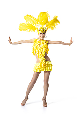 Image showing Beautiful young woman in carnival, stylish masquerade costume with feathers dancing on white studio background.