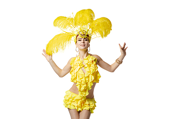 Image showing Beautiful young woman in carnival, stylish masquerade costume with feathers dancing on white studio background.