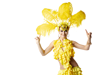 Image showing Beautiful young woman in carnival, stylish masquerade costume with feathers dancing on white studio background.