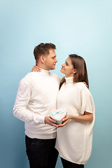 Image showing Beautiful couple in love on blue studio background. Valentine\'s Day, love and emotions concept