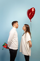 Image showing Beautiful couple in love on blue studio background. Valentine\'s Day, love and emotions concept