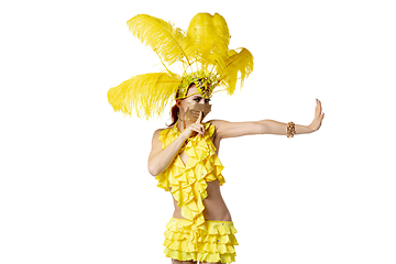 Image showing Beautiful young woman in carnival, stylish masquerade costume with feathers dancing on white studio background.