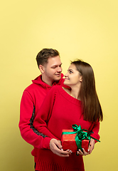 Image showing Beautiful couple in love on yellow studio background. Valentine\'s Day, love and emotions concept