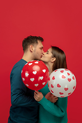 Image showing Beautiful couple in love on red studio background. Valentine\'s Day, love and emotions concept