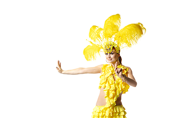 Image showing Beautiful young woman in carnival, stylish masquerade costume with feathers dancing on white studio background.