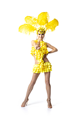 Image showing Beautiful young woman in carnival, stylish masquerade costume with feathers dancing on white studio background.