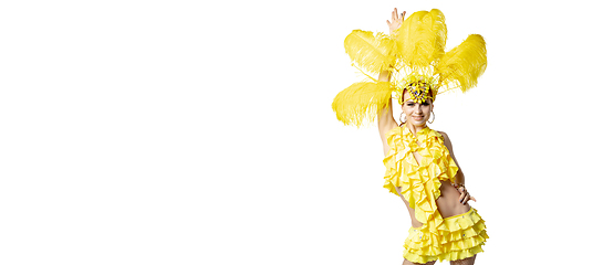 Image showing Beautiful young woman in carnival, stylish masquerade costume with feathers dancing on white studio background.