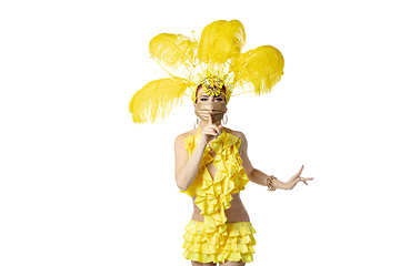 Image showing Beautiful young woman in carnival, stylish masquerade costume with feathers dancing on white studio background.