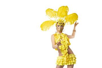 Image showing Beautiful young woman in carnival, stylish masquerade costume with feathers dancing on white studio background.