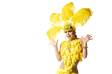 Image showing Beautiful young woman in carnival, stylish masquerade costume with feathers dancing on white studio background.