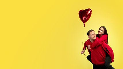 Image showing Beautiful couple in love on yellow studio background. Valentine\'s Day, love and emotions concept