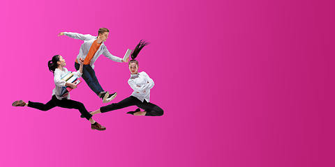 Image showing Happy office workers jumping and dancing in casual clothes or suit on gradient neon fluid background. Flyer with copyspace