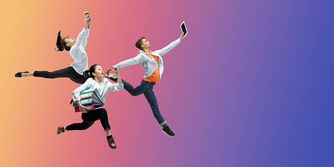 Image showing Happy office workers jumping and dancing in casual clothes or suit on gradient neon fluid background. Flyer with copyspace