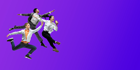 Image showing Happy office workers jumping and dancing in casual clothes or suit on gradient neon fluid background. Flyer with copyspace