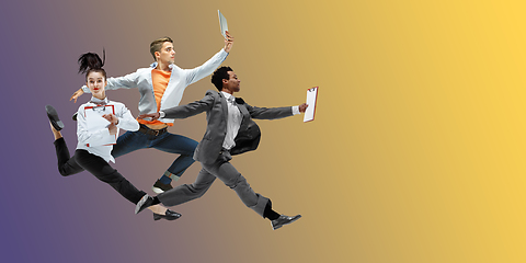 Image showing Happy office workers jumping and dancing in casual clothes or suit on gradient neon fluid background. Flyer with copyspace