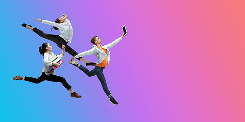 Image showing Happy office workers jumping and dancing in casual clothes or suit on gradient neon fluid background. Flyer with copyspace