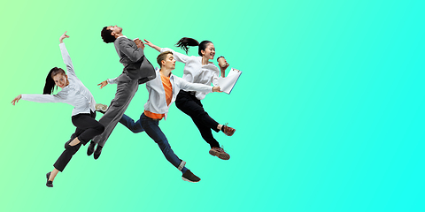 Image showing Happy office workers jumping and dancing in casual clothes or suit on gradient neon fluid background. Flyer with copyspace